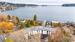 Nanaimo apartment for rent - A curved building sits in the foreground of a residential area.