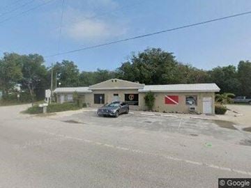 Key Largo apartment for rent - A car is parked in front of a building with a red and white sign on it.