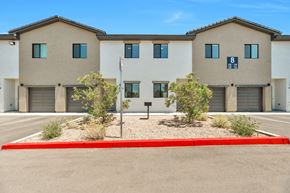 Phoenix apartment for rent - a building with three garages and a flag in front of it