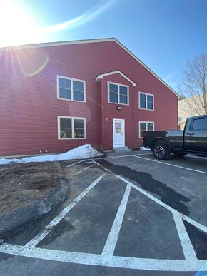 Laconia apartment for rent - a red building with a truck parked in front of it