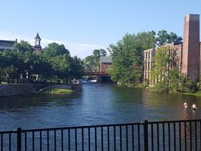 Laconia apartment for rent - a river flowing through a city with buildings and a bridge