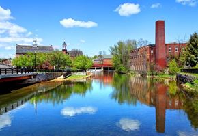 Laconia apartment for rent - a river running through a city with buildings and trees