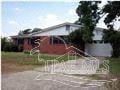 Pensacola house for rent - A red brick house with a white garage door.