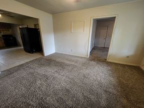 Pensacola house for rent - a living room with a carpeted floor and a door to a bedroom