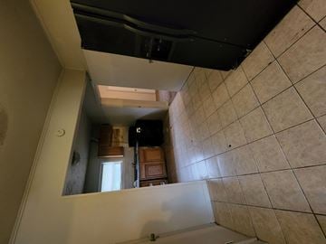 Pensacola house for rent - the view from the top of the stairs looking down into the kitchen of a house