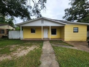 Pensacola house for rent - a yellow house with a sidewalk in front of it