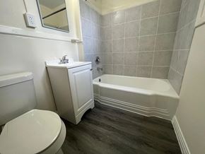 Fort Myers apartment for rent - A white toilet sits next to a white sink in a small bathroom.