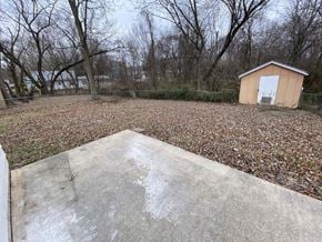 Clinton house for rent - A shed sits in a backyard with a concrete slab in the foreground.