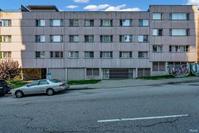 Vancouver apartment for rent - A silver car is parked on the street in front of a grey building.