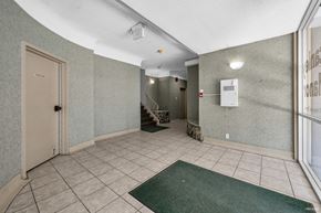 Vancouver apartment for rent - A hallway with a green rug on the floor and a white door on the left.