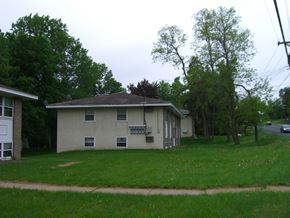 Stillwater apartment for rent - a white house with a lawn and trees