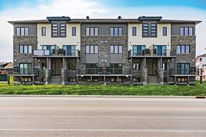Ottawa apartment for rent - A large, modern building with a balcony on the second floor.