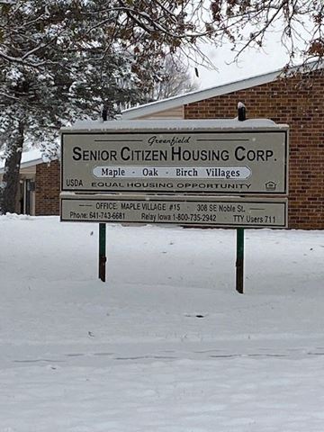 Greenfield apartment for rent - a sign in the snow in front of a building