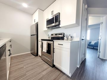 Ste. Anne apartment for rent - A modern kitchen with white cabinets and stainless steel appliances.