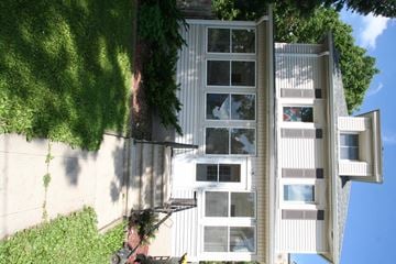 Rochester apartment for rent - A tall white building with a lot of windows and a tree in front of it.