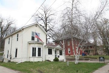 Red Wing house for rent - a white house with an flag in front of a red house