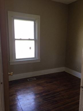Windsor house for rent - a small room with a window and wooden floors