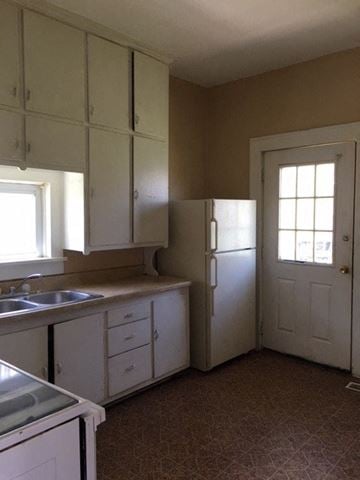 Windsor house for rent - an empty kitchen with a sink and a refrigerator