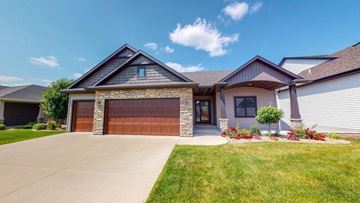 Rochester house for rent - A house with a brown garage door and a stone pillar.