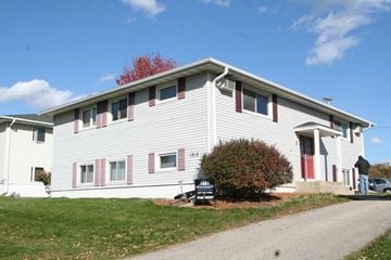 Rochester apartment for rent - a white building with red shutters and a sign in front