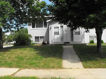 Rochester apartment for rent - A white house with a grey roof and a tree in front.