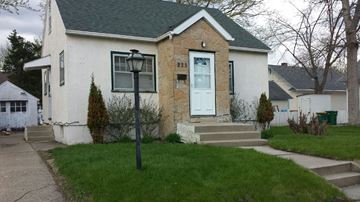 Rochester house for rent - A white house with a green roof and a white door.