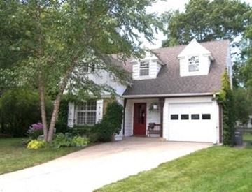 Rochester house for rent - A white house with a red door and a garage.