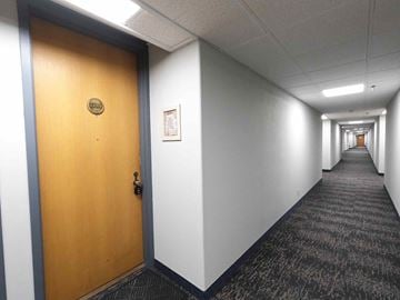 Rochester apartment for rent - A hallway with a wooden door at the end.