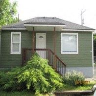 Pullman house for rent - A green house with a white door and windows.