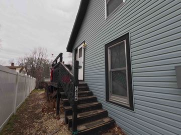 Red Wing apartment for rent - A house with a blue siding and a black railing.