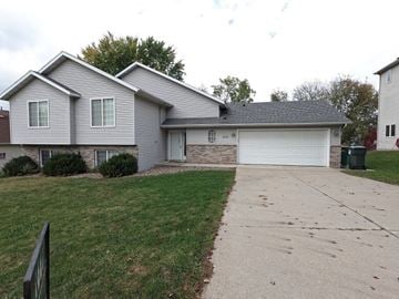 Rochester house for rent - a white house with a driveway in front of it