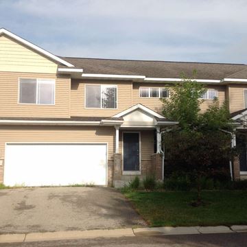 Rochester apartment for rent - A house with a white garage door and a brown roof.