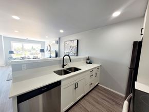 Beausejour apartment for rent - A modern kitchen with a stainless steel dishwasher and white countertops.
