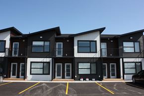 Beausejour apartment for rent - A building with a parking lot in front of it.