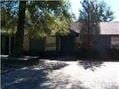 Pensacola house for rent - a house with trees and a dirt road in front of it