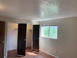 Boulder apartment for rent - A room with a window, two doors, and a wooden floor.