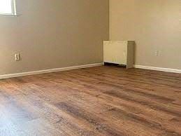 Boulder apartment for rent - A room with wooden flooring and a white appliance.