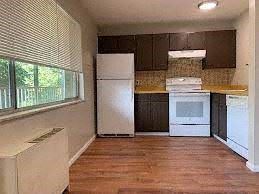 Boulder apartment for rent - A kitchen with white appliances and wooden floors.