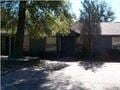 Pensacola house for rent - a house with trees and a dirt road in front of it