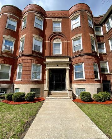 Chicago apartment for rent - A red brick building with a black door and windows.