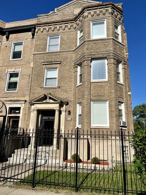 Chicago apartment for rent - a tall brick building with a gate in front of it