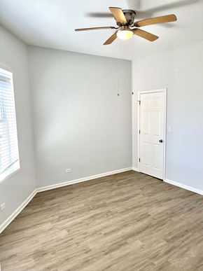 Chicago apartment for rent - an empty bedroom with a ceiling fan and a door