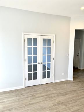 Chicago apartment for rent - an empty room with white doors and a wood floor