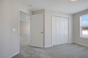 Hugo house for rent - a bedroom with two closets and a door to a hallway
