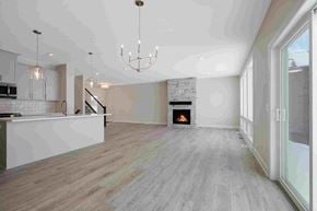Hugo house for rent - an empty living room with a fireplace and a kitchen