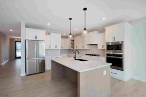 Lake Elmo house for rent - a large white kitchen with stainless steel appliances and a large island