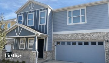 Lewisville house for rent - a blue house with a gray garage door in front of it