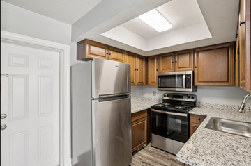 North Fort Myers apartment for rent - A kitchen with a refrigerator, microwave, oven, and sink.