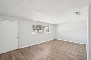 Fort Myers apartment for rent - A room with a white door and a window with a view of trees.