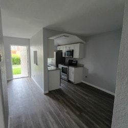 Fort Myers apartment for rent - A kitchen with white cabinets and a black fridge.